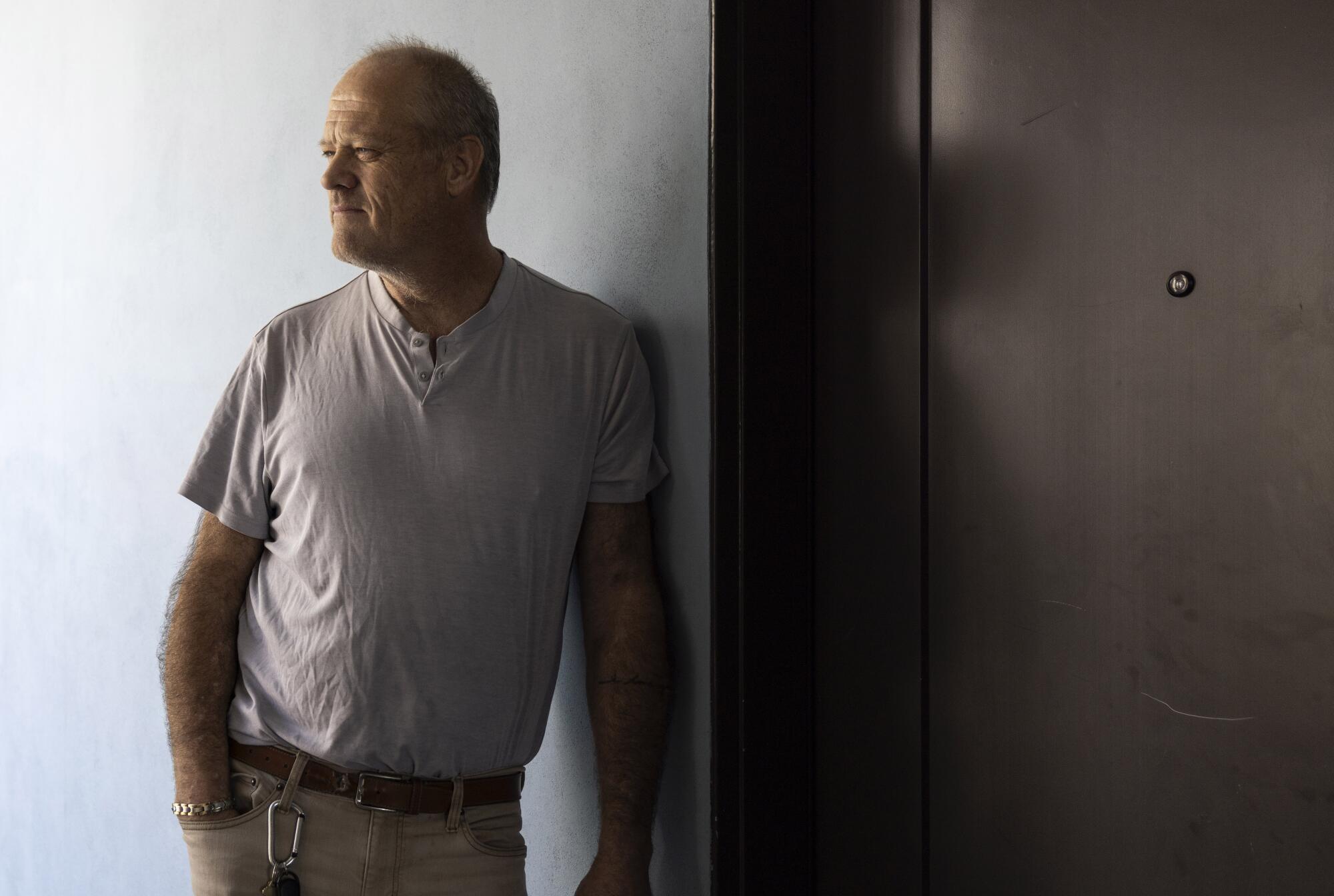 Sean Johnson leans against a wall outside his unit in an affordable housing complex.