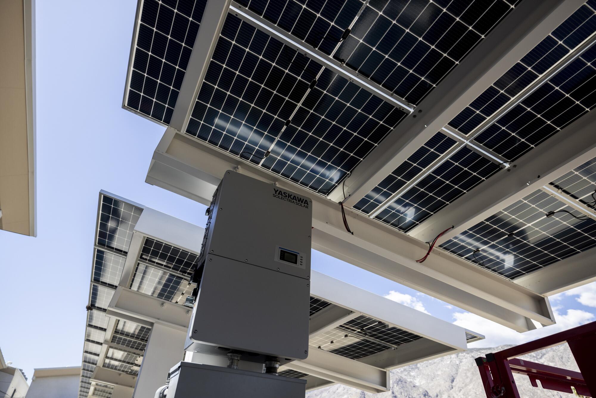 Large solar panels rise above a parking lot.