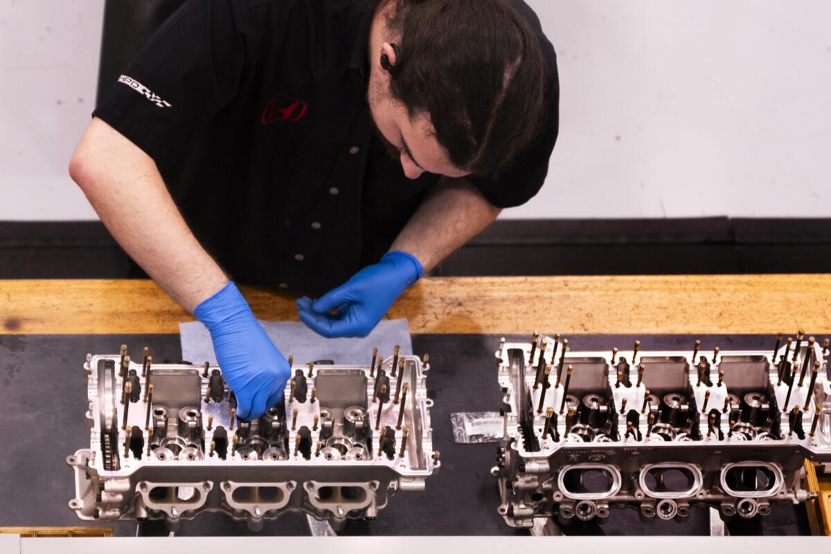 A technician in the HRC machine shop works on an engine.