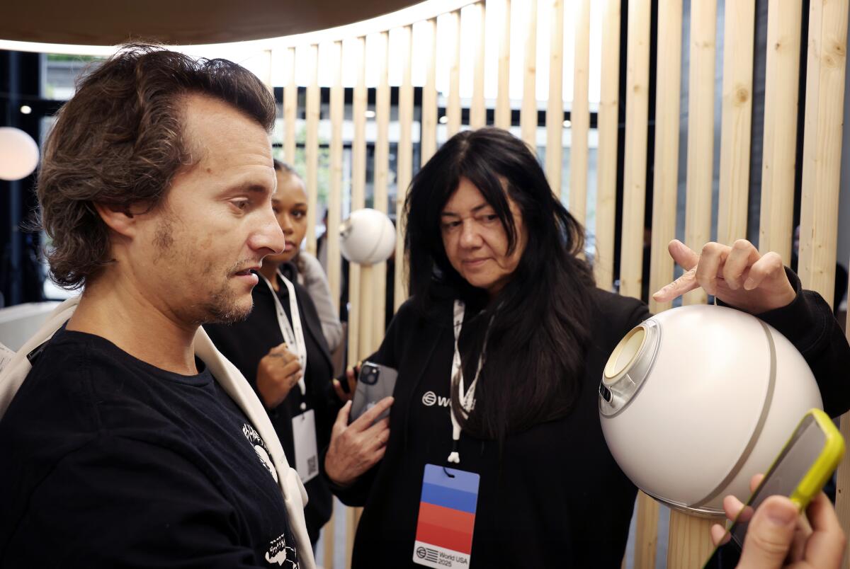 Frankie Reina, left, gets an eye scan with the help of Myra Vides, center.