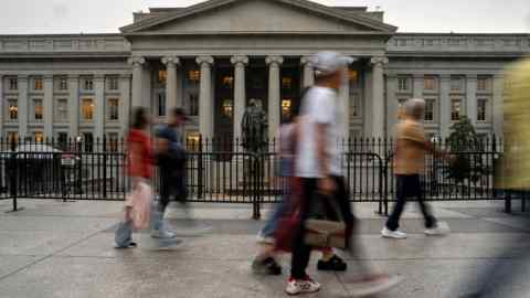 People walk in front of the US Treasury building in Washington