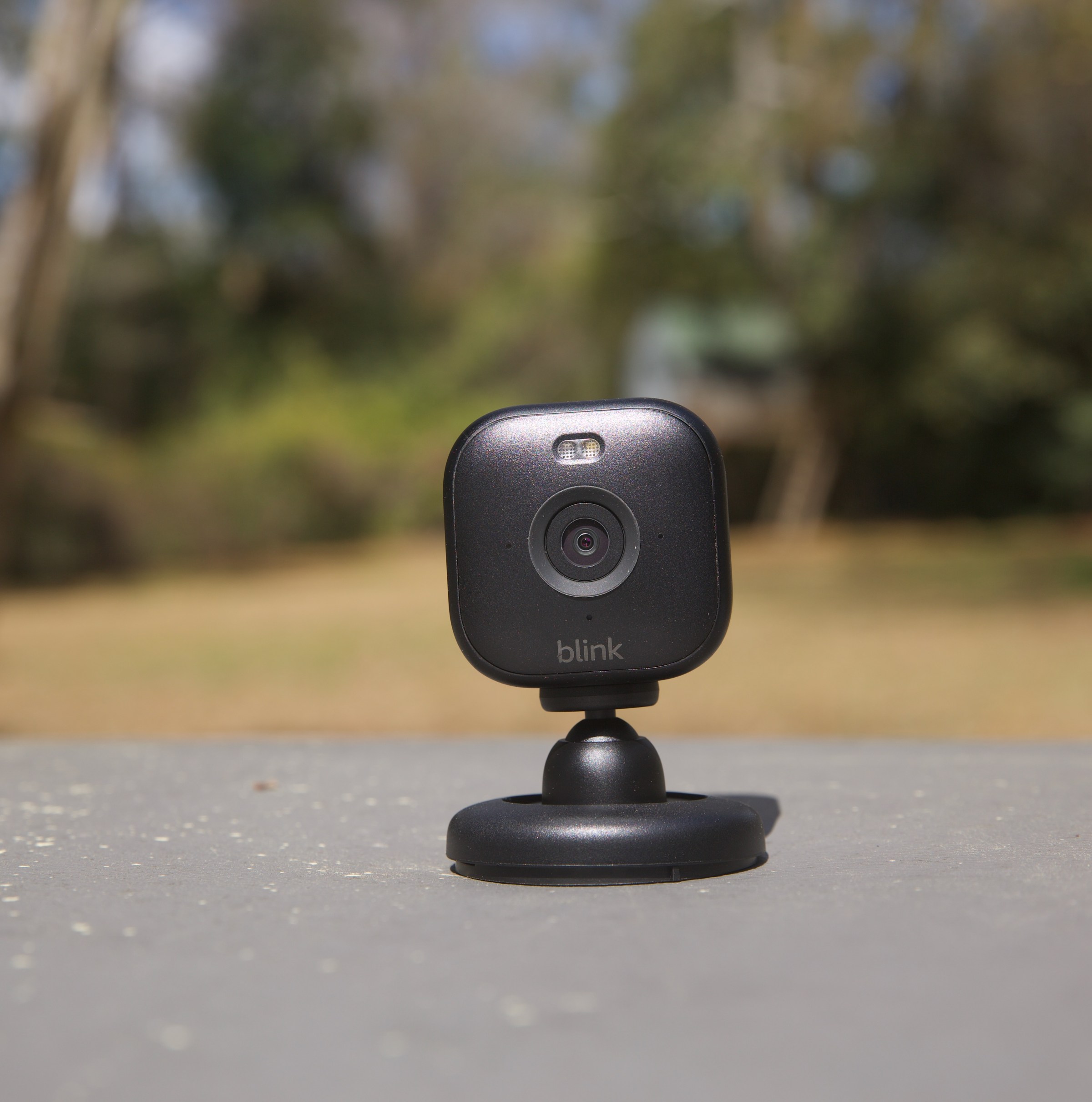 The Blink Mini 2 sitting on a table outside.