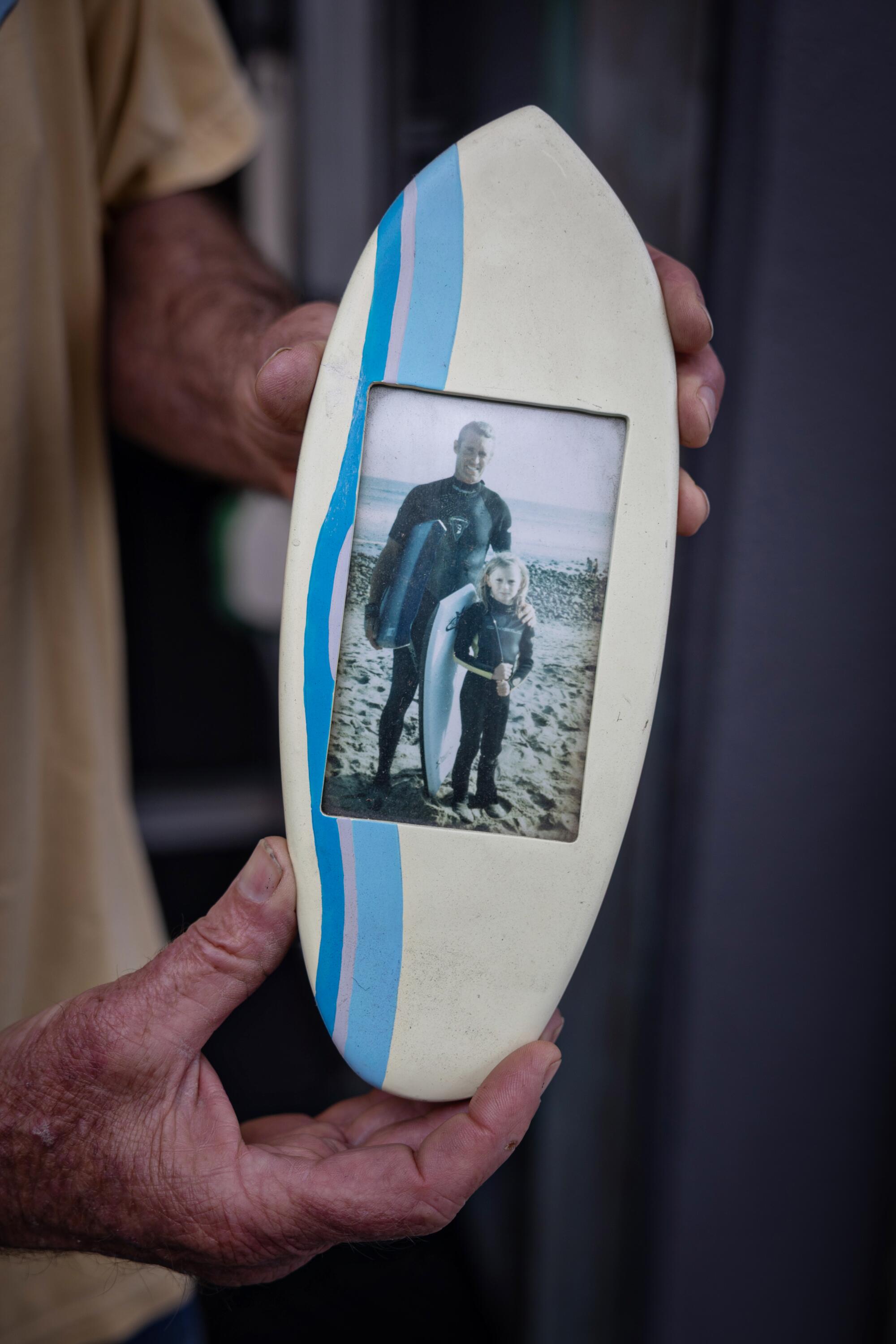 a man hold a photo of himself and his daughter