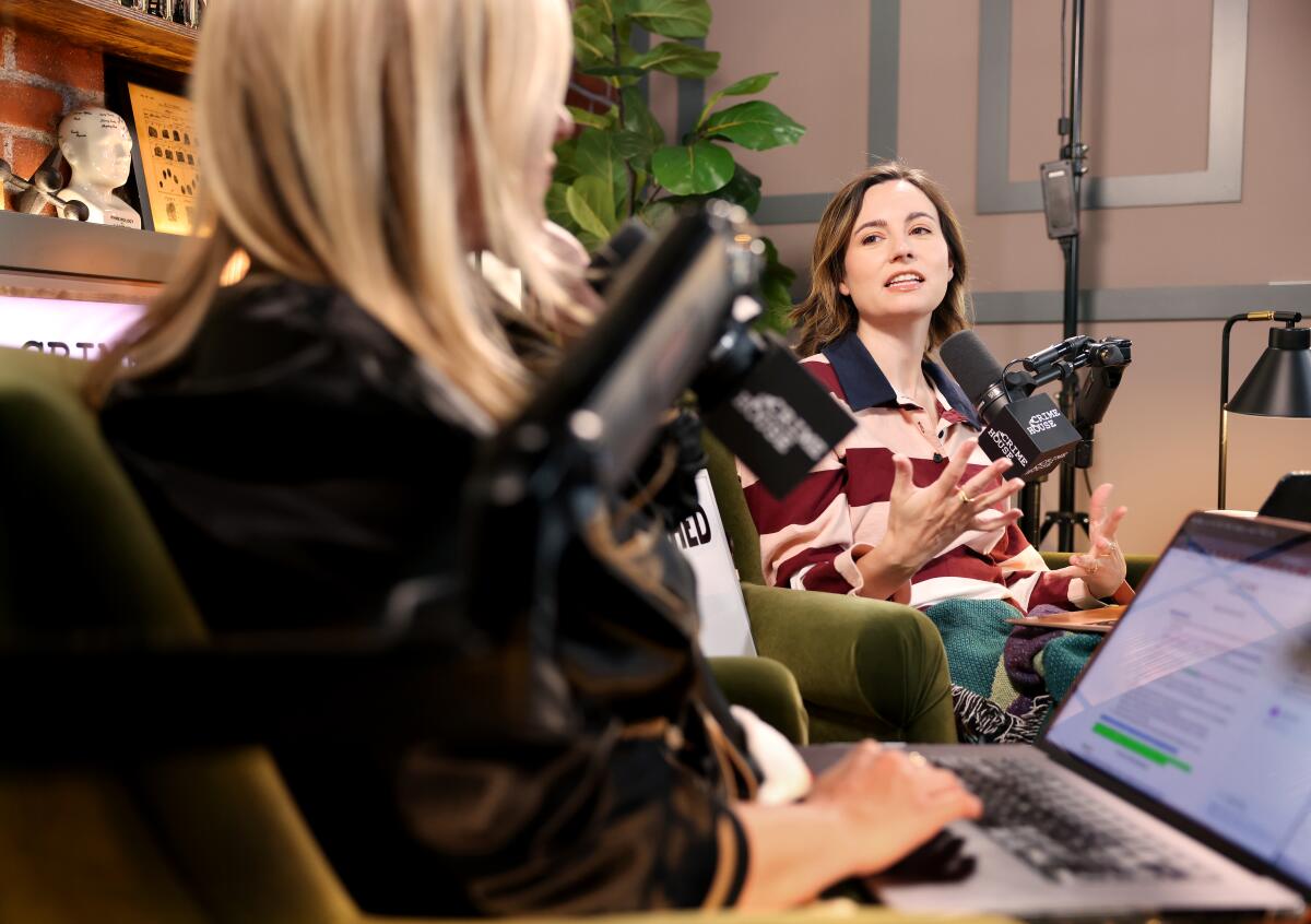 Two podcasters record in a studio