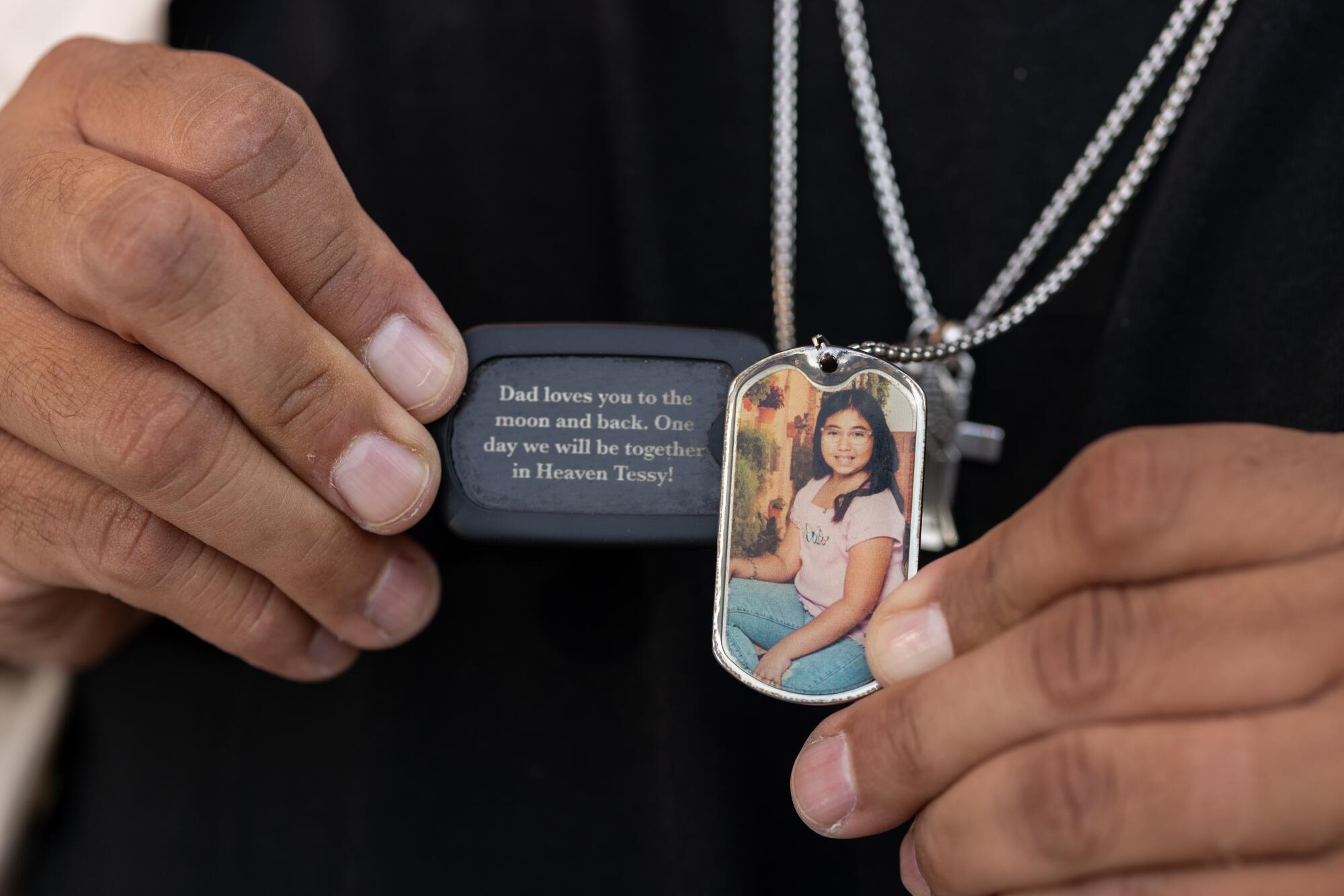 Jerry Mata holds dog tag necklaces of his daughter Tess in front of the Spring Street Courthouse in Los Angeles.