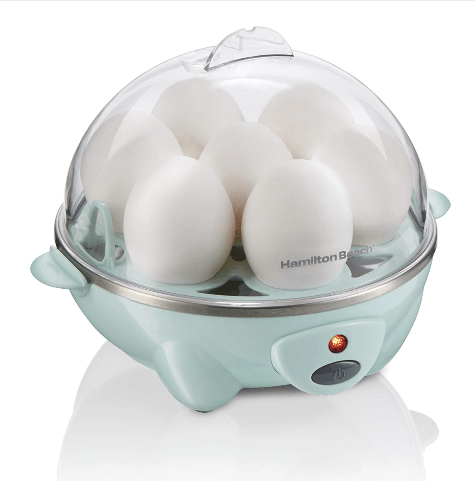 Egg cooker with see-through top and seven eggs inside.