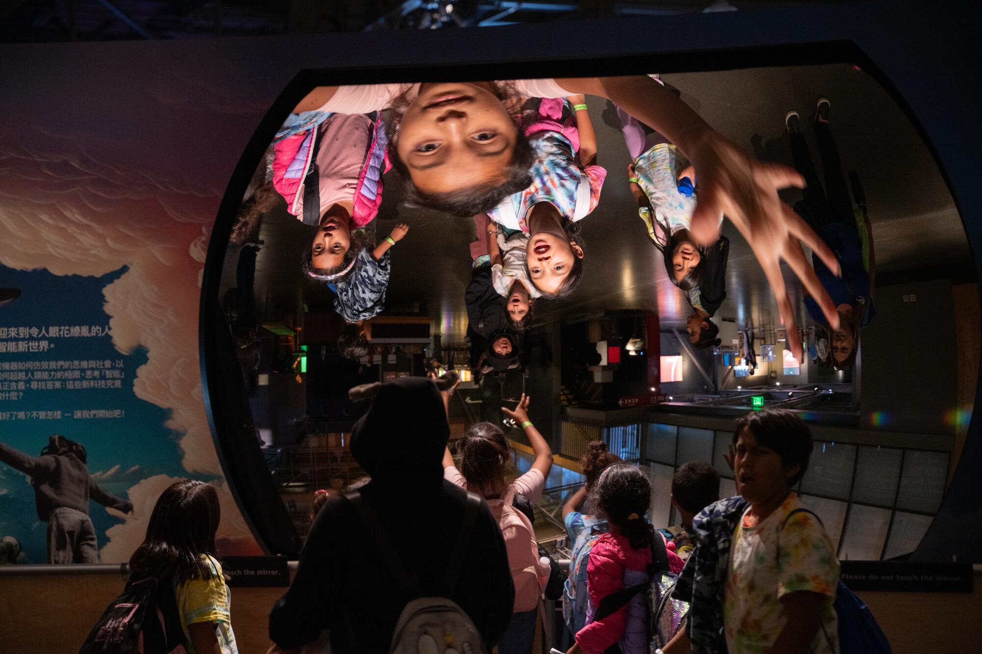 Children interact with the "Giant Mirror" at the Exploratorium's "Adventures in AI" exhibition