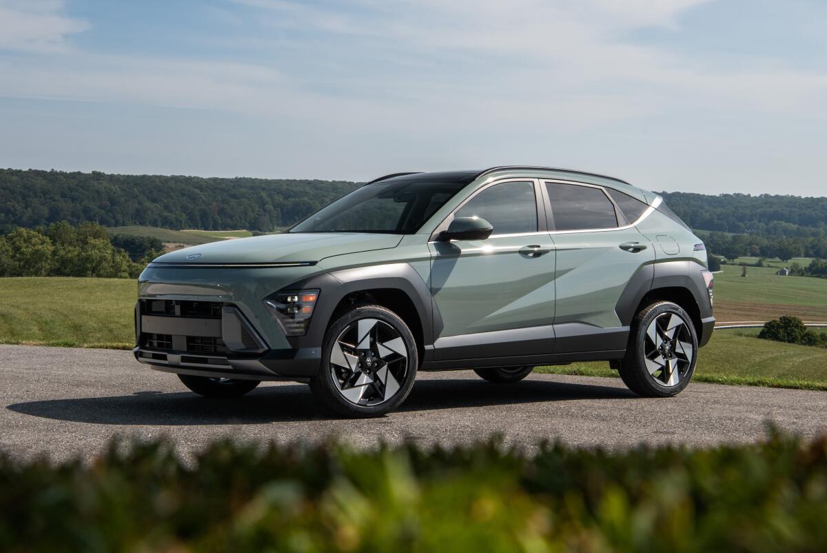 A pale blue-green vehicle in a green landscape