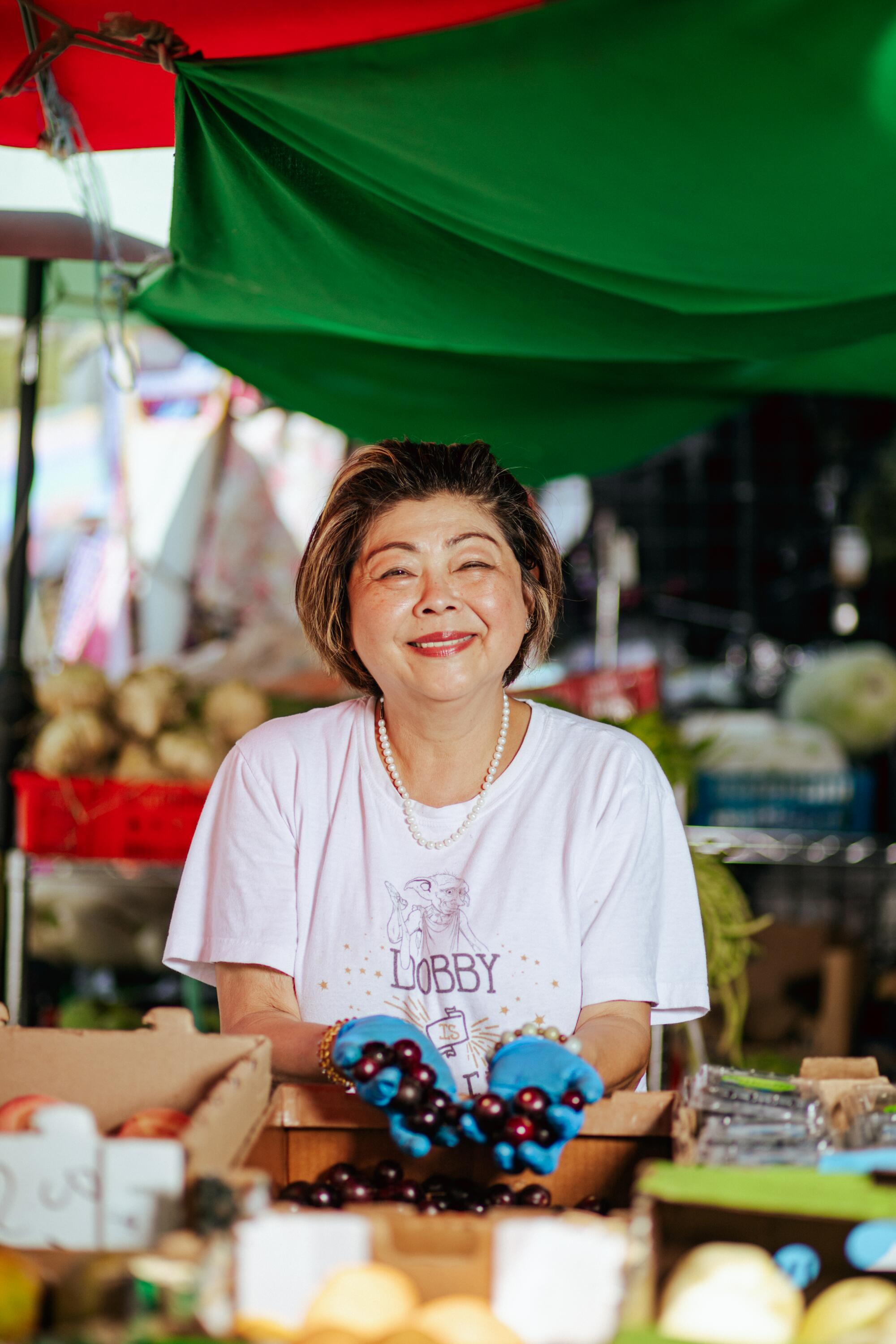 Yue Wa Market owner Amy Tran holds some of the fresh produce available at her store.