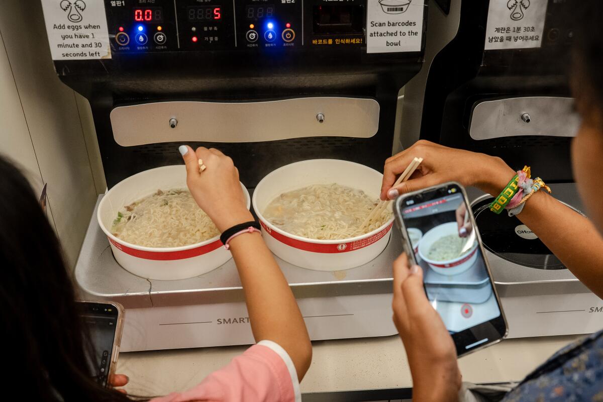 Shoppers prepare their dinner at one of the self-serve machines in the dining area at a CU ramyon convenience store.