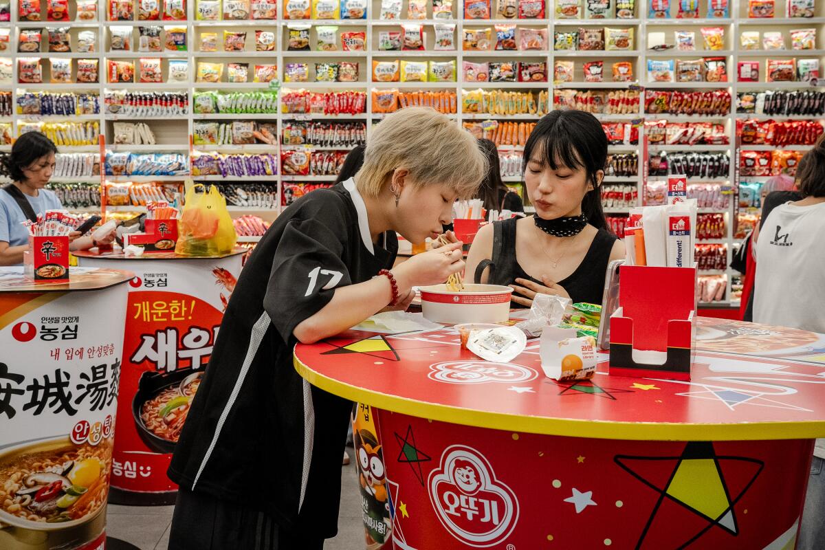 Ye Yan and her girlfriend, Quan Chuxi, eat ramyon, kimchi and sausage at a CU convenience store.