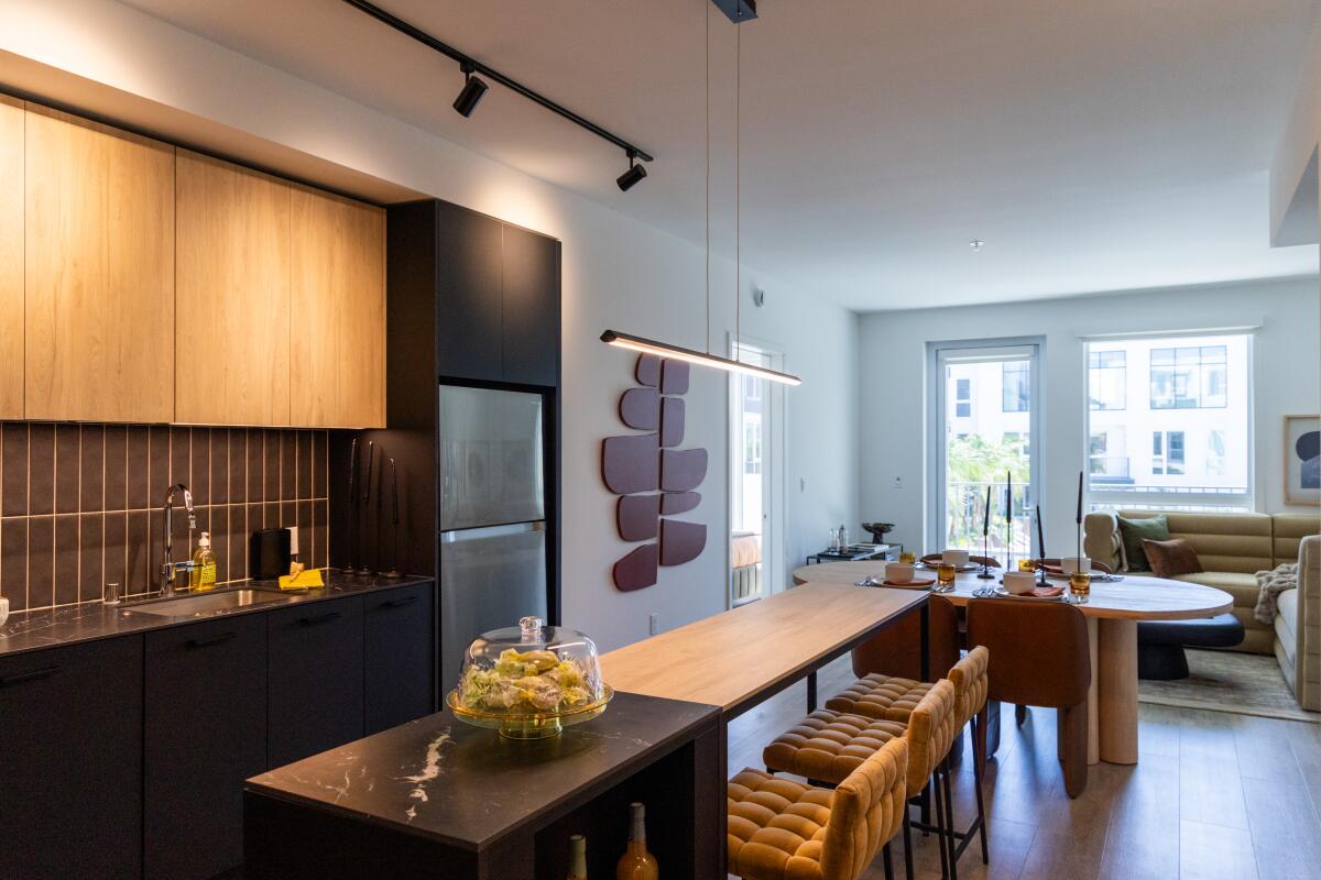 The kitchen and living room area of a two-bedroom den unit at the new Overland & Ayres Apartments.